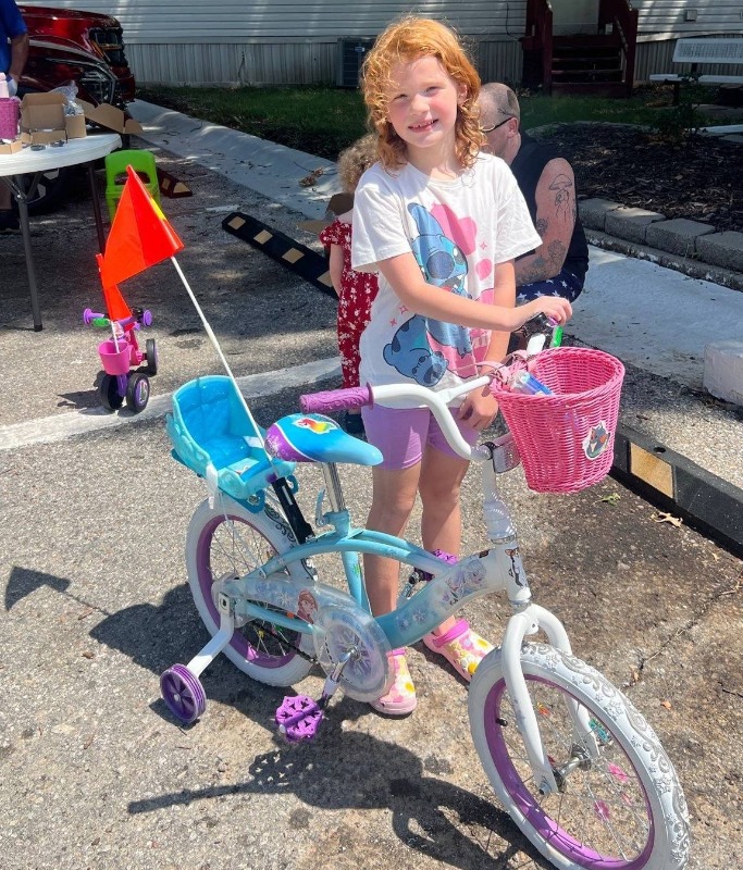 A girl shows off her decorated bike from a Bayshore Bike Bling Bash
