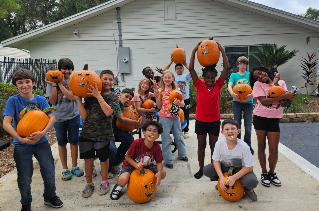 A group of Bayshore community children celebrating fall with pumpkin painting activities