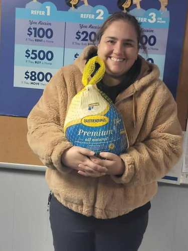 A Turkey Dinner Giveaway winner holding the turkey she won