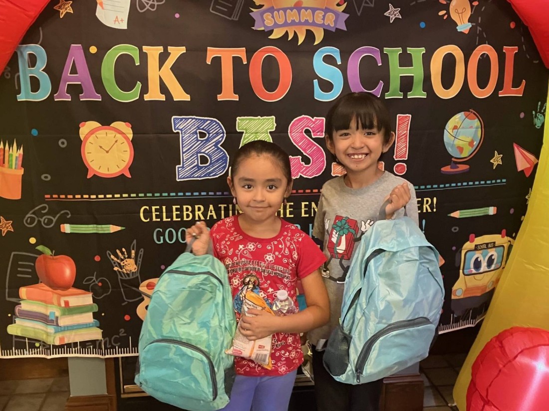 Children holding backpacks at a Back to School Bash event hosted by RHP Social and Bayshore Manufactured Homes