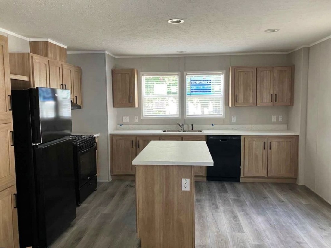Kitchen of a brand-new manufactured home in Ohio, featuring fridge, dishwasher, range, and kitchen island