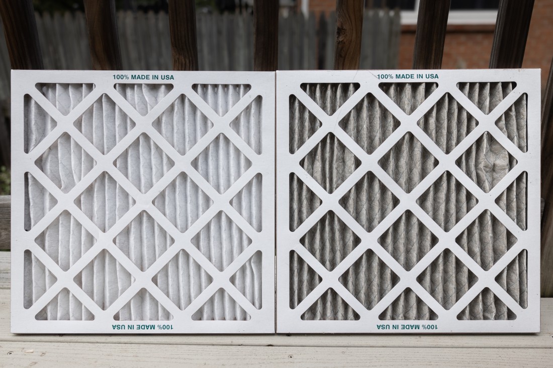A clean furnace filter on the left compared to a dirty furnace filter on the right