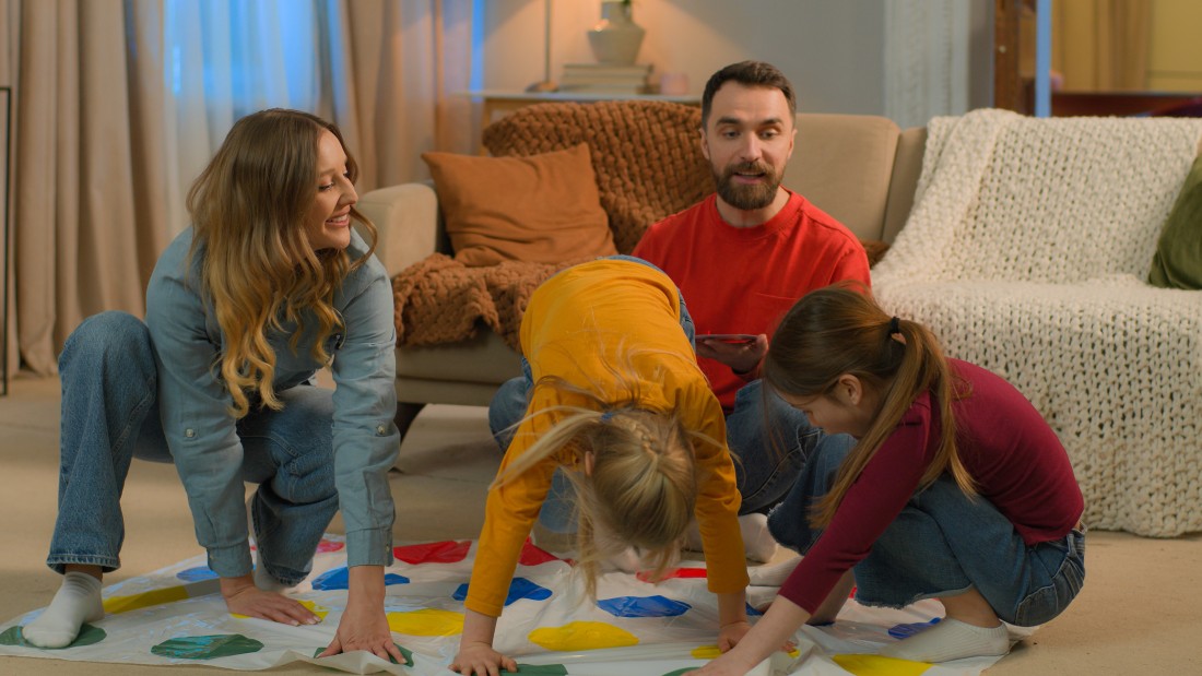 Parents and children playing board games together at a dining table inside a manufactured home.