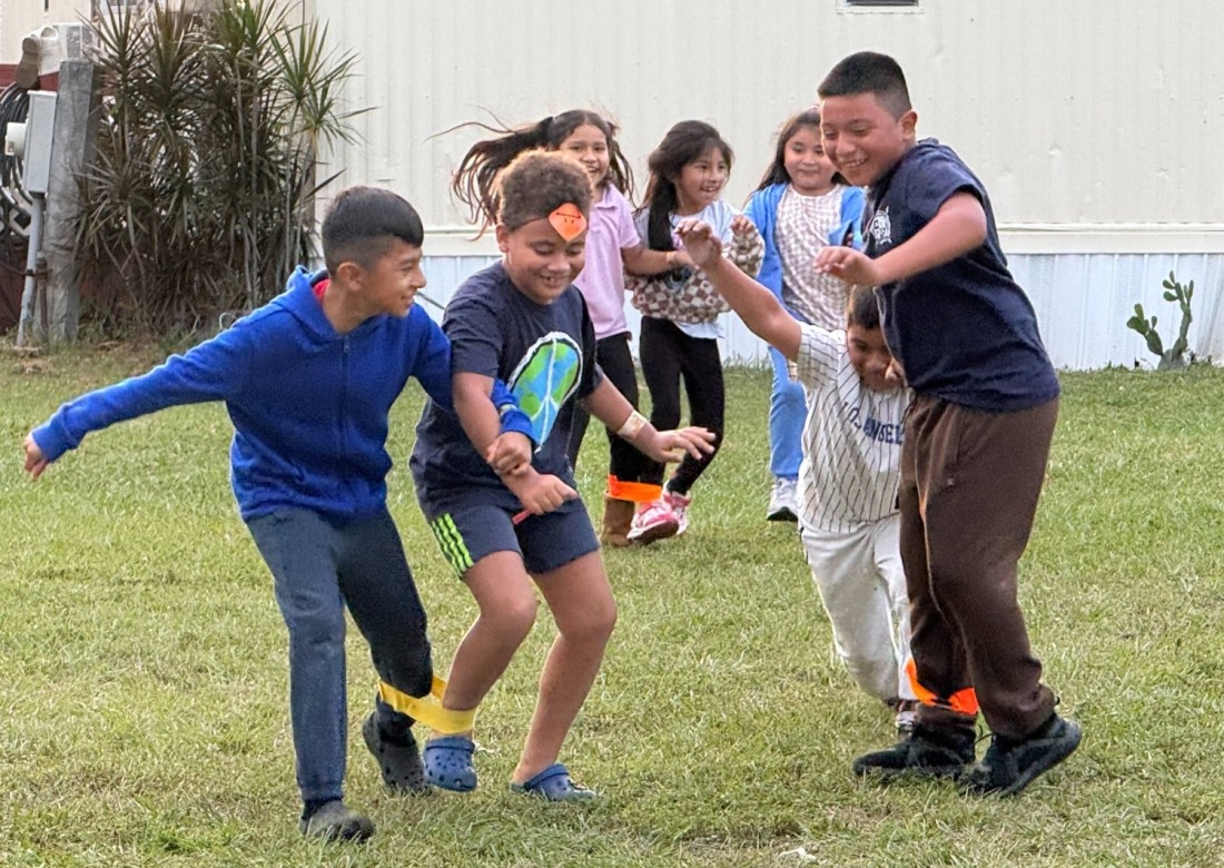 Kids in a Bayshore manufactured home community play a three-legged race game