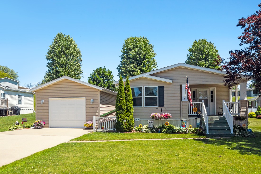 A modern manufactured home in the Alpine Park Community (Dubuque, IA), showcasing features like porch, garage, & more