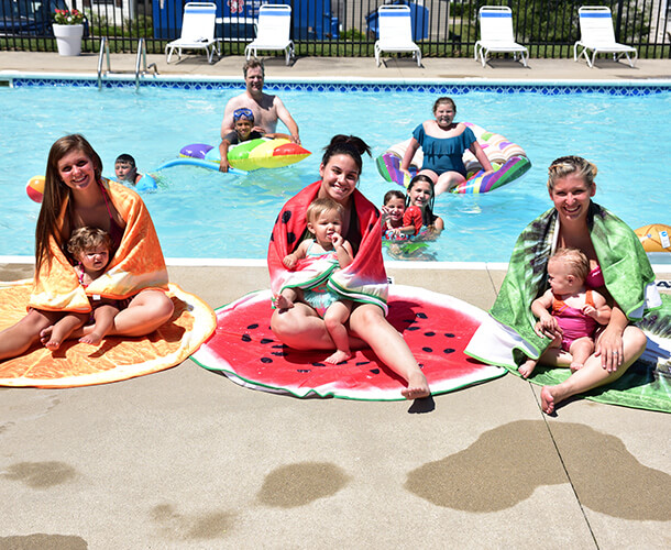 children and parents playing in the swimming pool in their manufactured home community